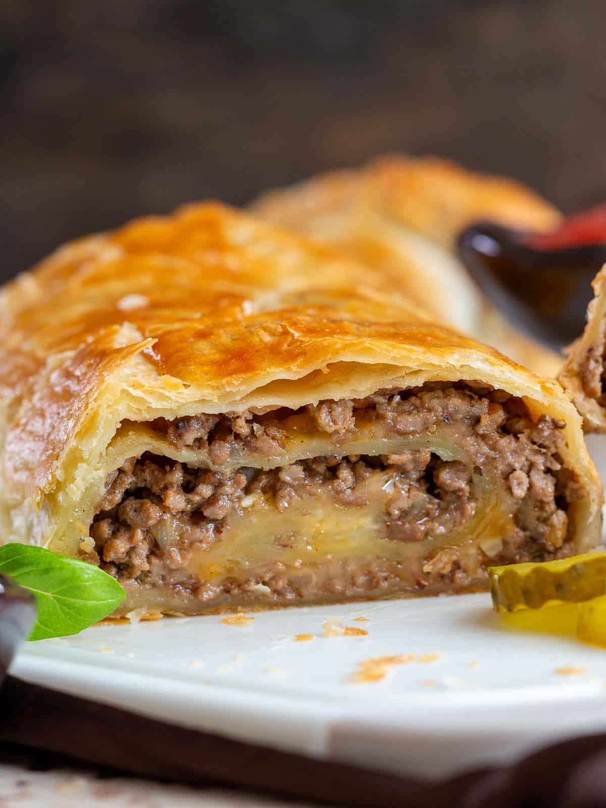 Baked Cheeseburger puff pastry sliced showing the melty cheese. 