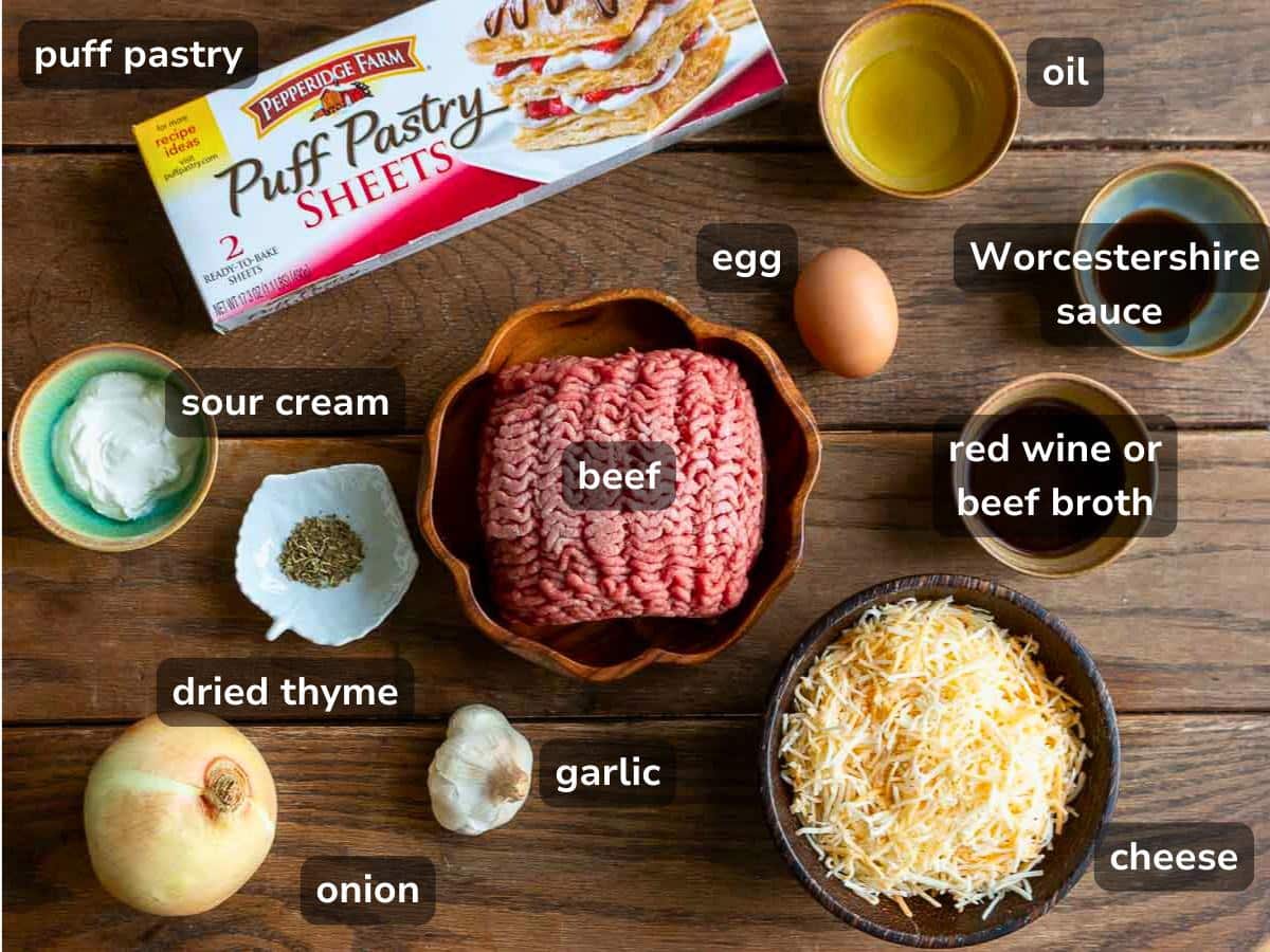 ingredients cheese and beef puff pastry laid out on a wooden table. 