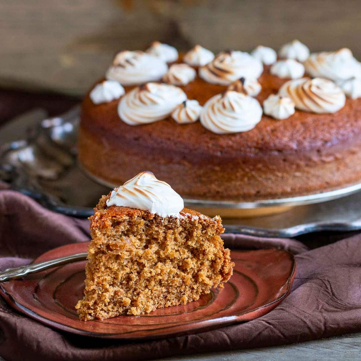 A slice of spiced coffee cake on a handmade brown pottery plate. 