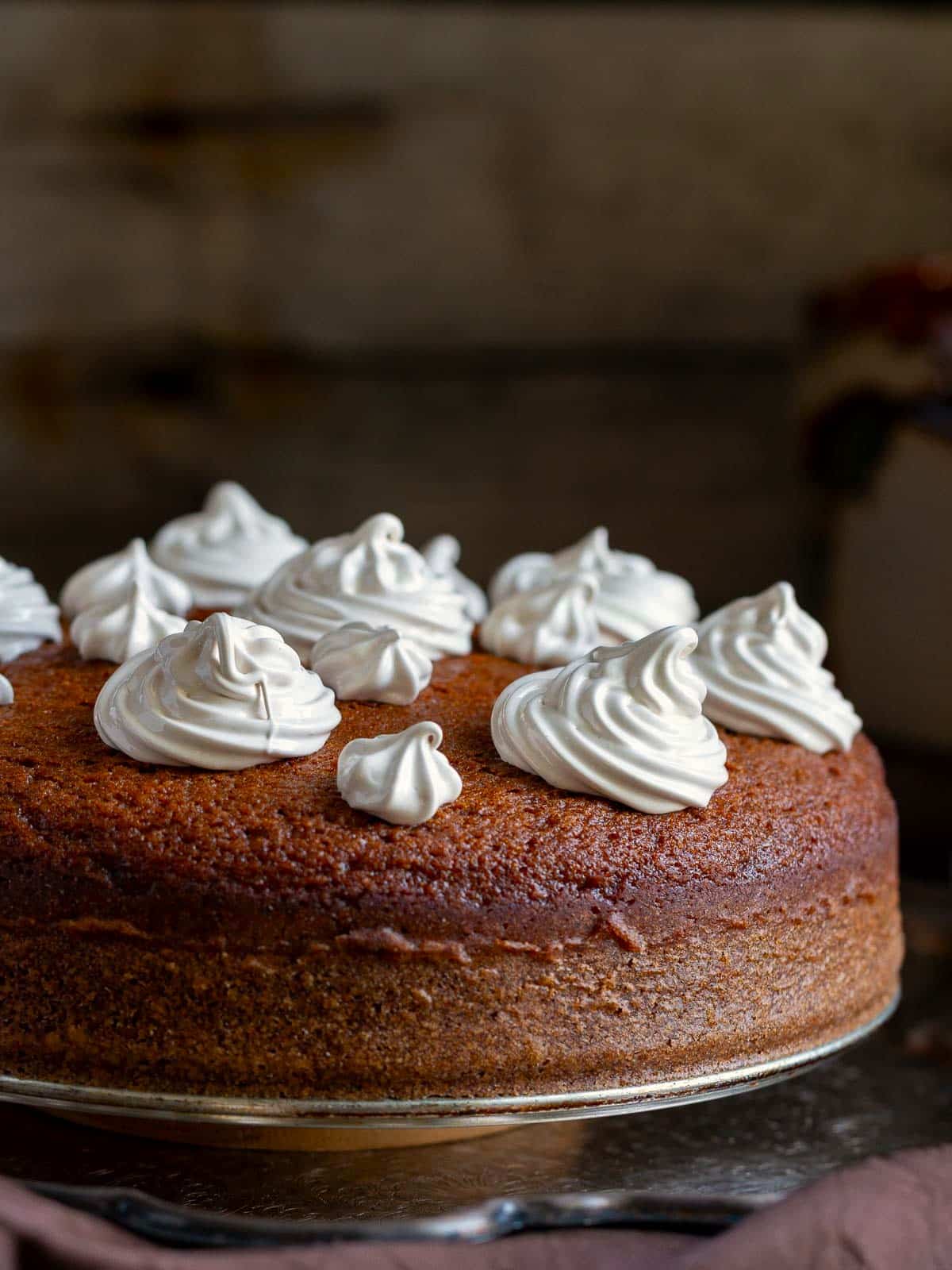 Freshly piped espresso Swiss meringue on top of cake before being toasted with the kitchen torch. 