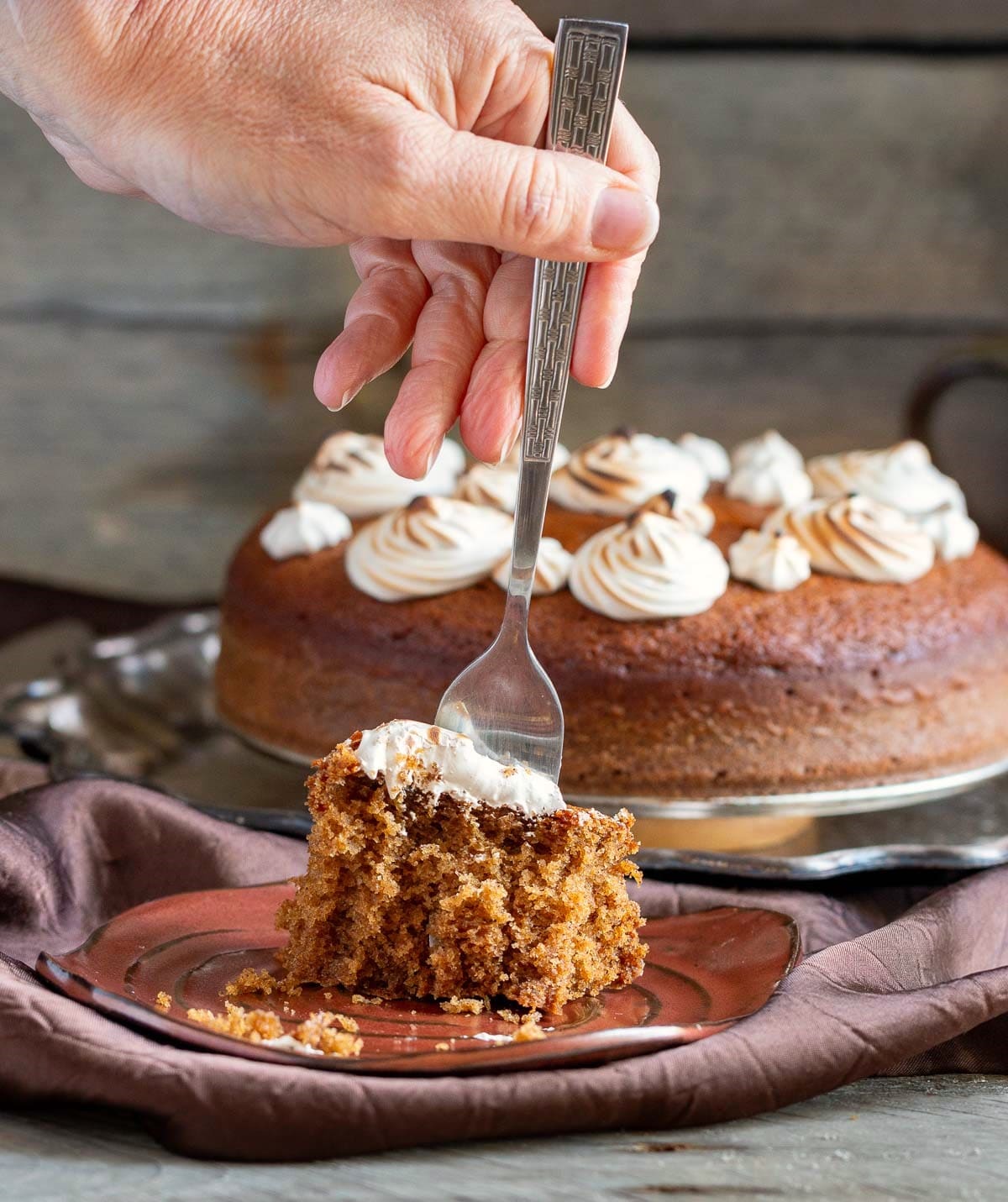 Taking a fork bite out of the cake frosted with espresso meringue.