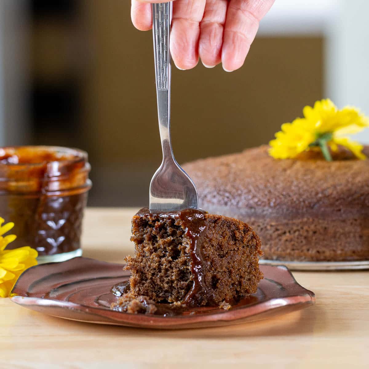 Taking a bite out of the cake topped with coffee sauce. 