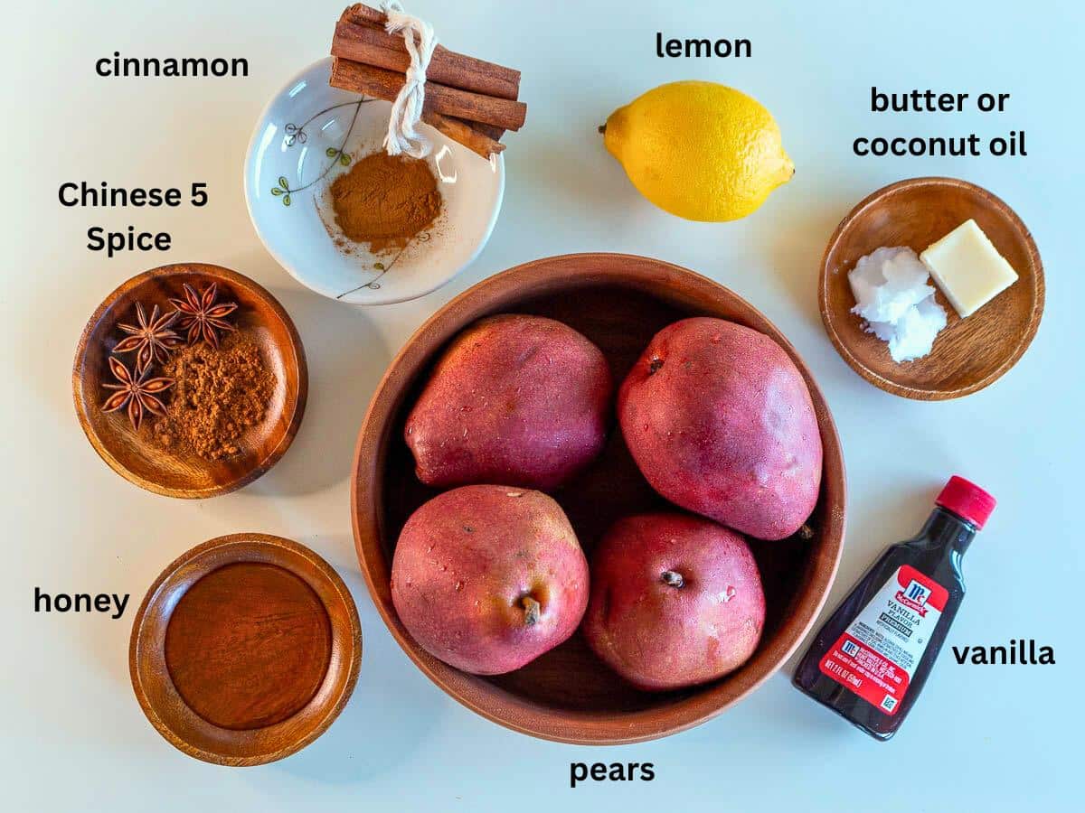 Ingredients to make a baked spiced pear dessert on a white table.