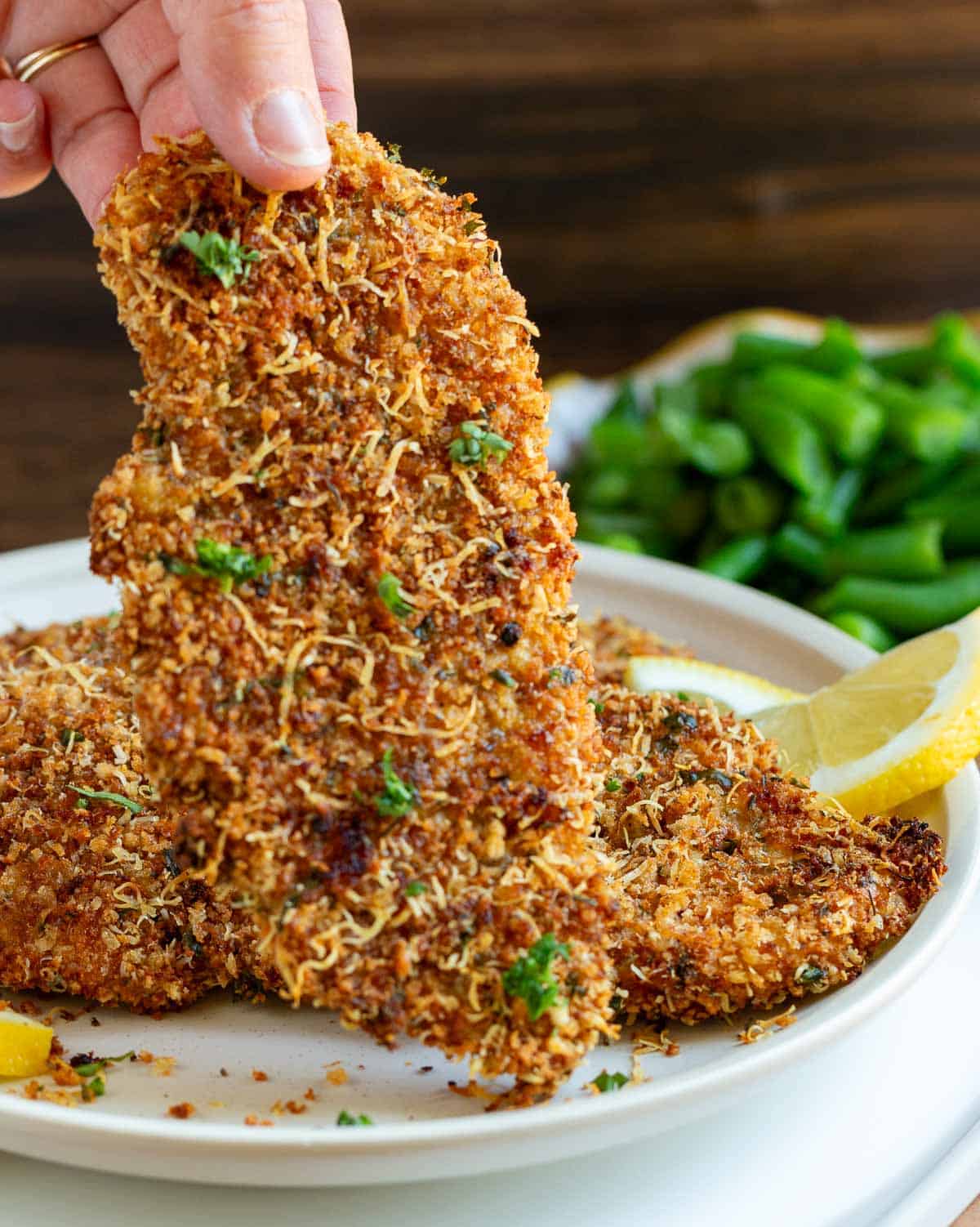 Holding a crispy chicken Milanese in our fingers.