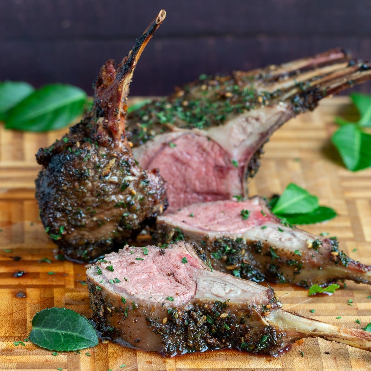 Grilled rack of lab with herbs carved on a wooden board. 