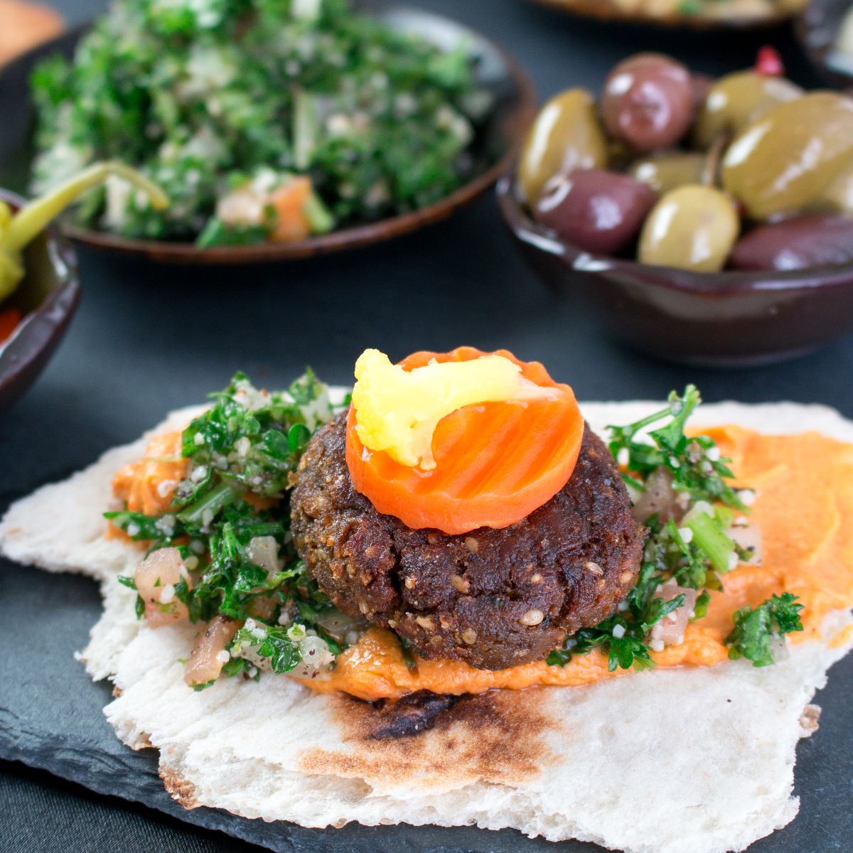 Middle Eastern party food with falafel bites, hummus, Mujadara, baba ghanoush, tabbouleh and flat breads for sharing. 