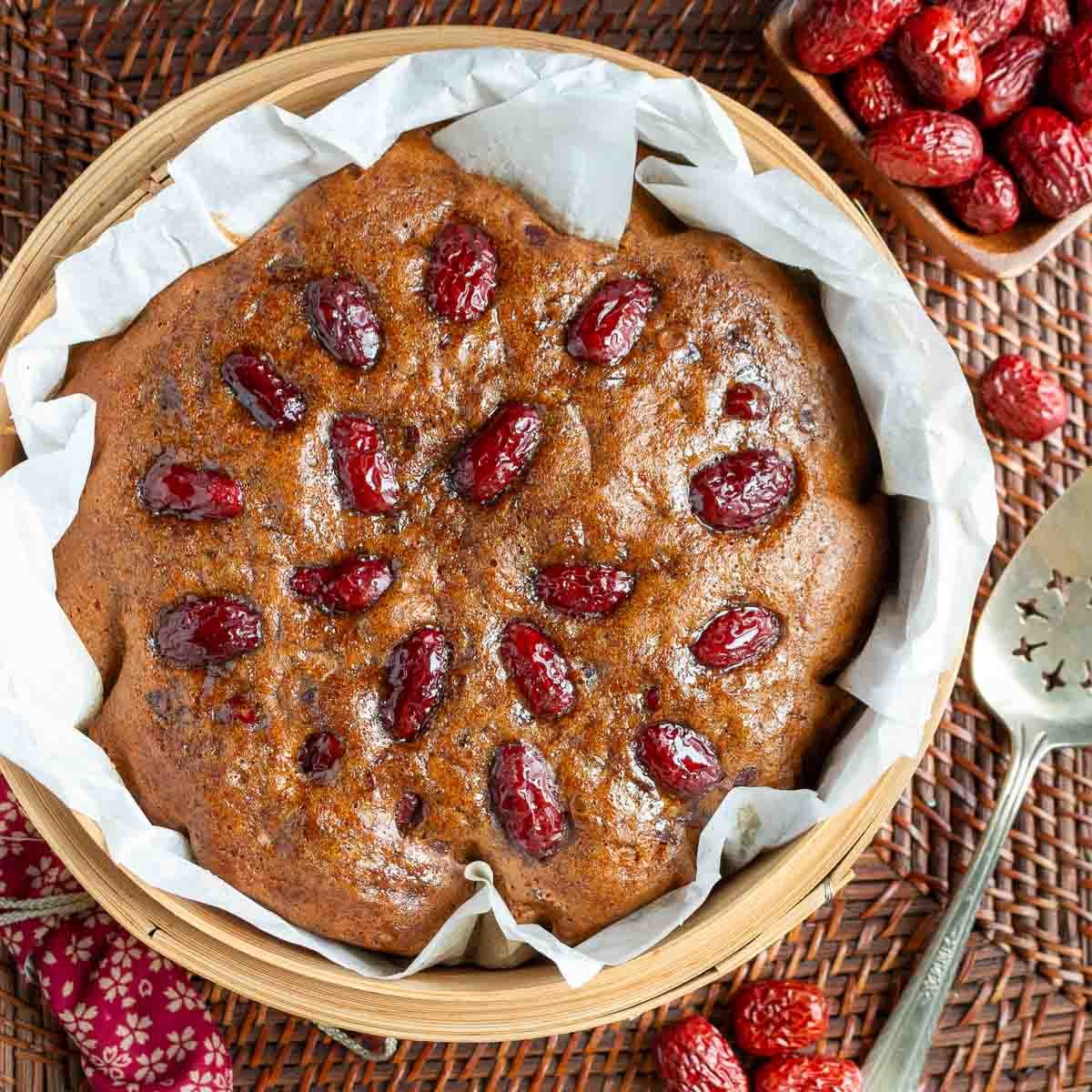 Steamed gingerbread in a steamer basket studded with red dates. 