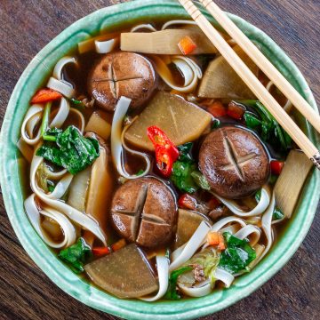 Delicious top down photo of Chinese Beef Noodle Soup Recipe in a green bowl with chopsticks.