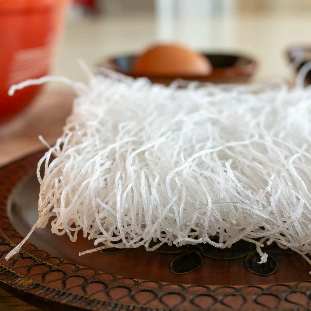 Dried mung bean vermicelli noodles laid on a wooden bowl. 