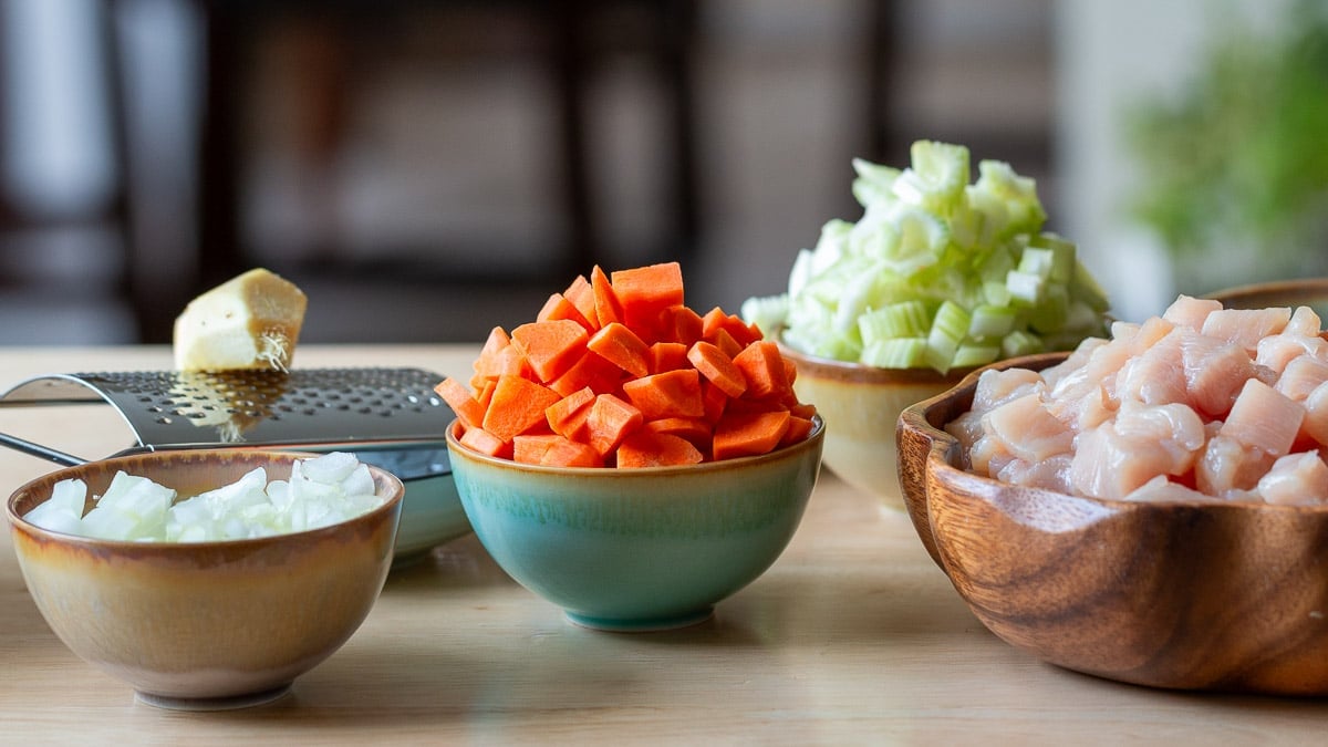 Chopped carrots, celery, onions in separate bowls.