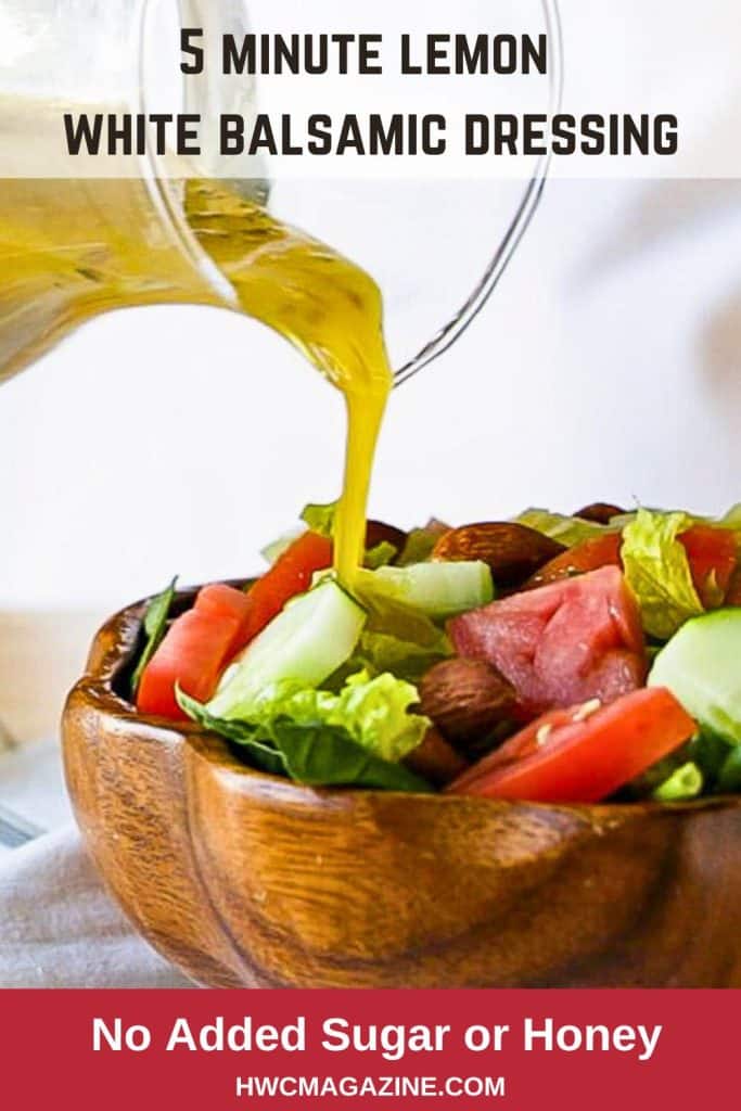 Bright yellow and emulsified lemon white balsamic vinegar pouring over a crisp fresh salad.