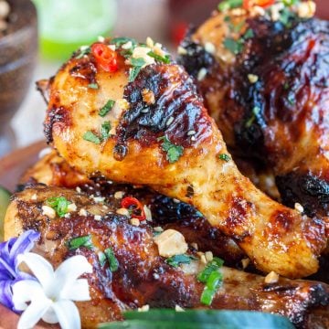 Air Fryer Crispy Curry Chicken Legs garnished with peanuts and chilis.