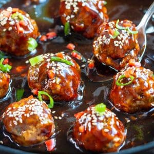 Juicy venison meatballs slathered in a homemade Asian zing sauce in a pan.